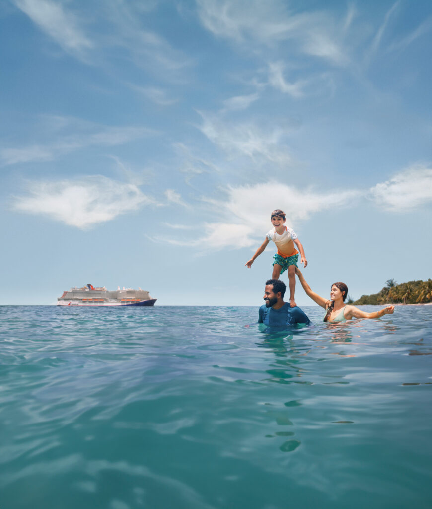 Family playing in the water beside Carnival Cruise Line ship